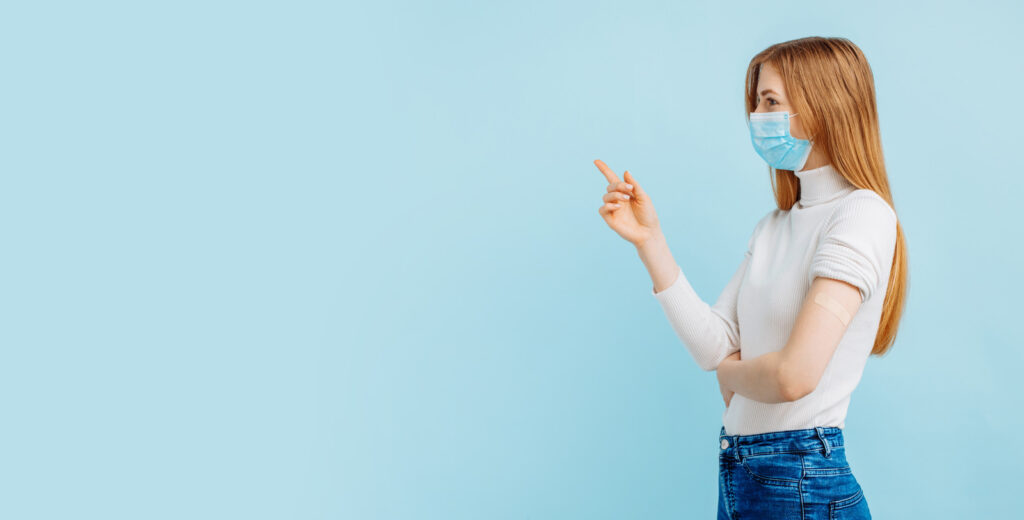 Lady standing in a white shirt wearing a mask